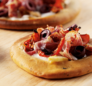 Pizza with goat’s cheese, Parma ham and fresh olives