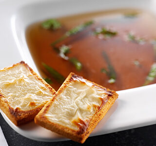 Beef consommé with haricot verts and toast with ERU Spreadable Goat Cheese