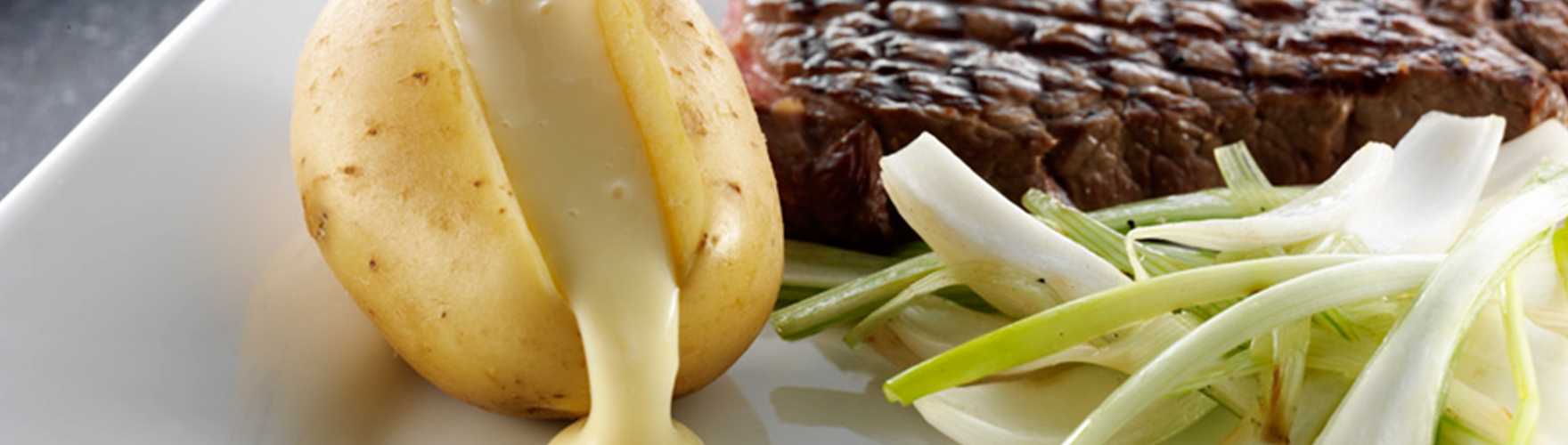 Grilled prime rib served with potatoes filled with ERU Spreadable Gouda, and braised fennel