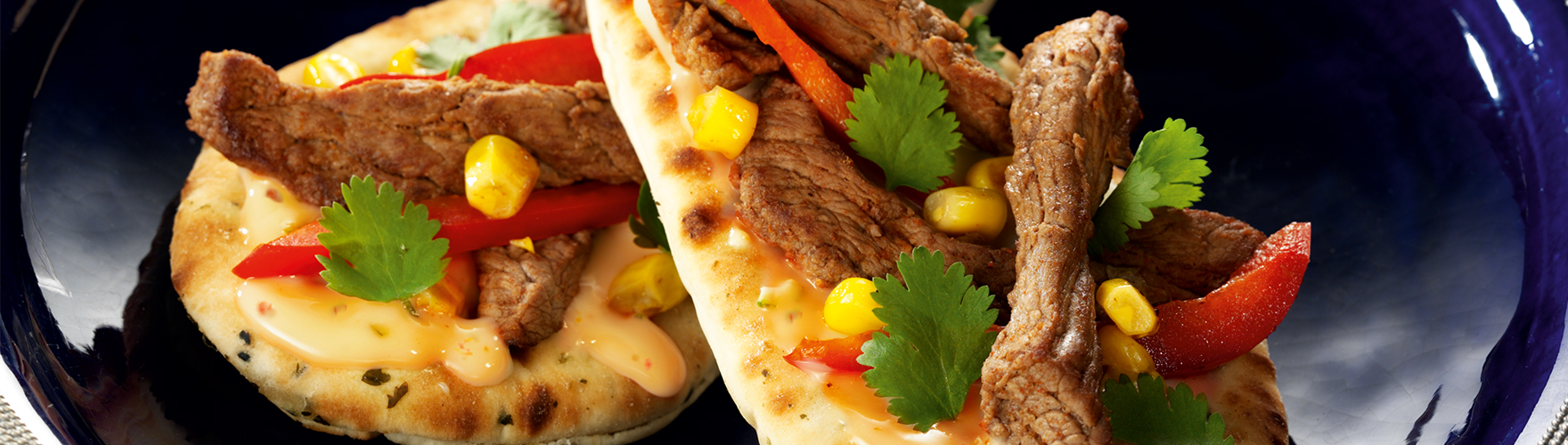 Naan sandwich with sliced beef, sweet corn and peppers