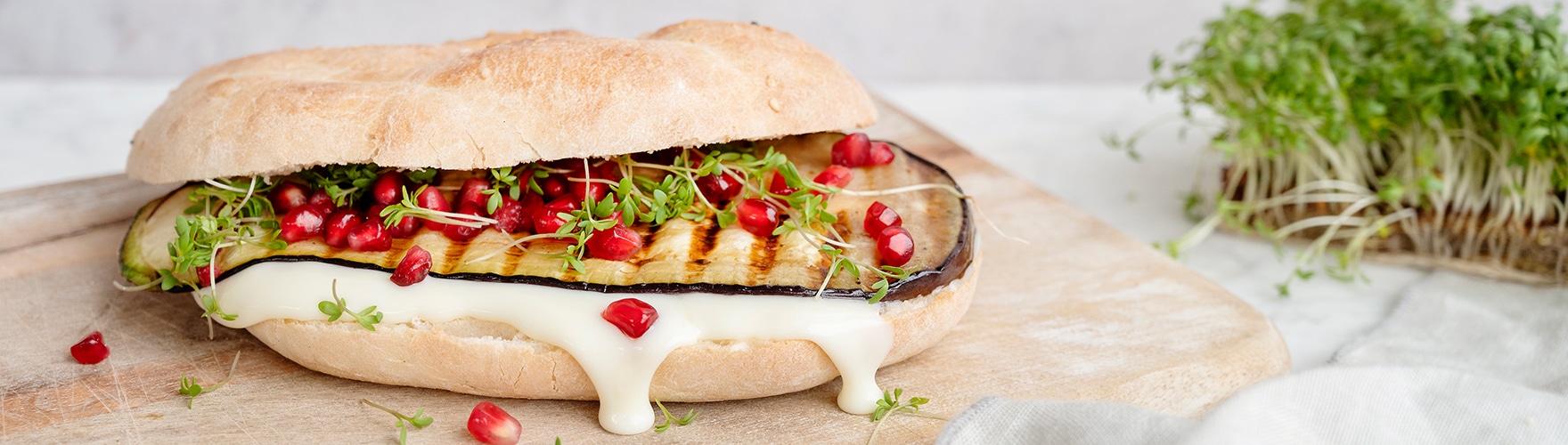 Turks broodje met gegrilde aubergine, granaatappelpitten, tuinkers en belegen kaas